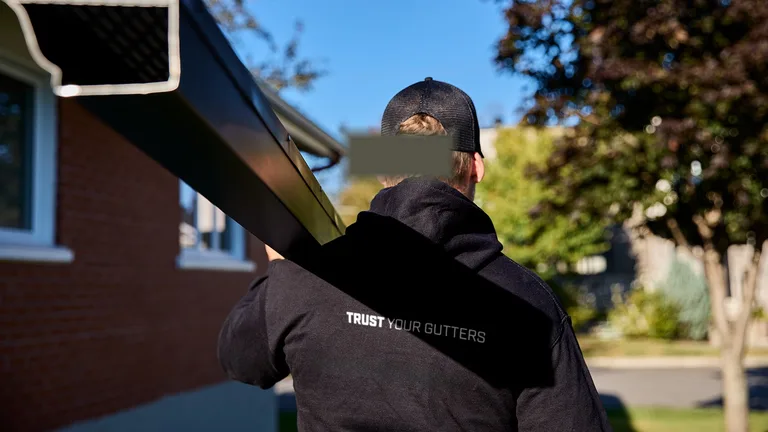 Clearing leaves from a gutter at the roofline — Metro Vancouver debris season